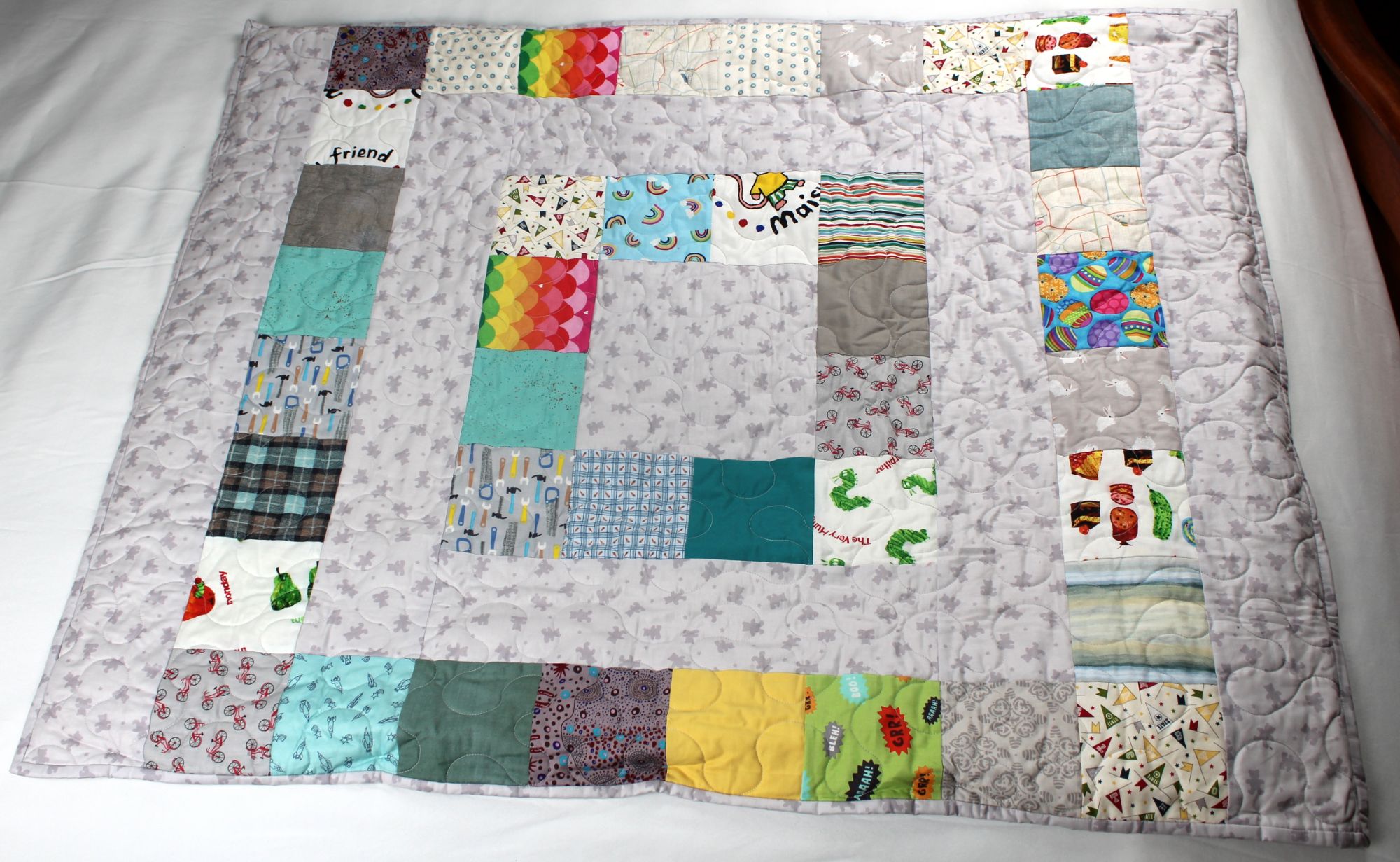 Hopscotch Storytime handmade lavender weighted quilt, scrappy patchwork squares on a gray teddy bear and star print